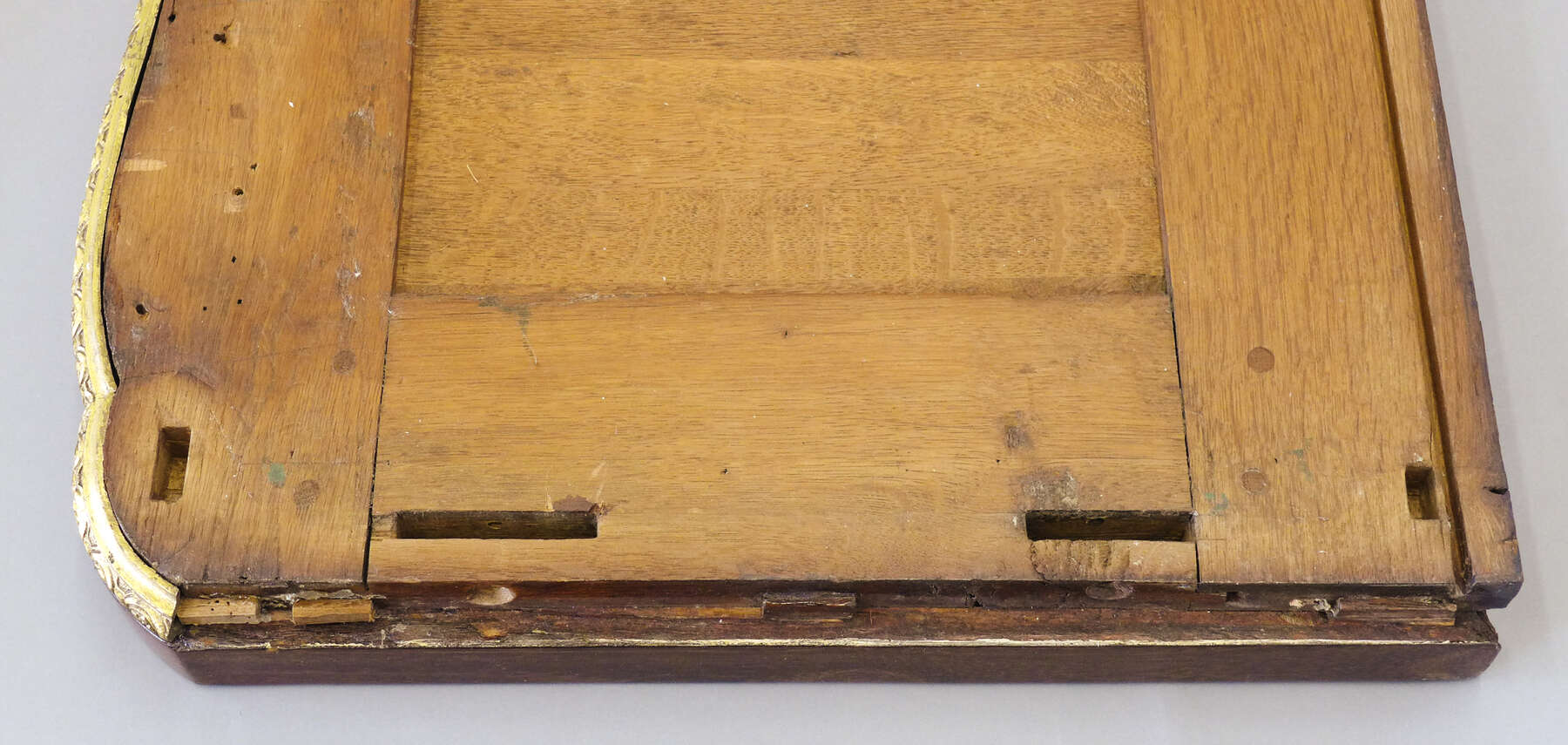 a detail of the underside of the cabinet top shows two vertical wooden panels and one horizontal wooden panel with four rectangular gaps near the edges used to join the top of the cabinet to the bottom