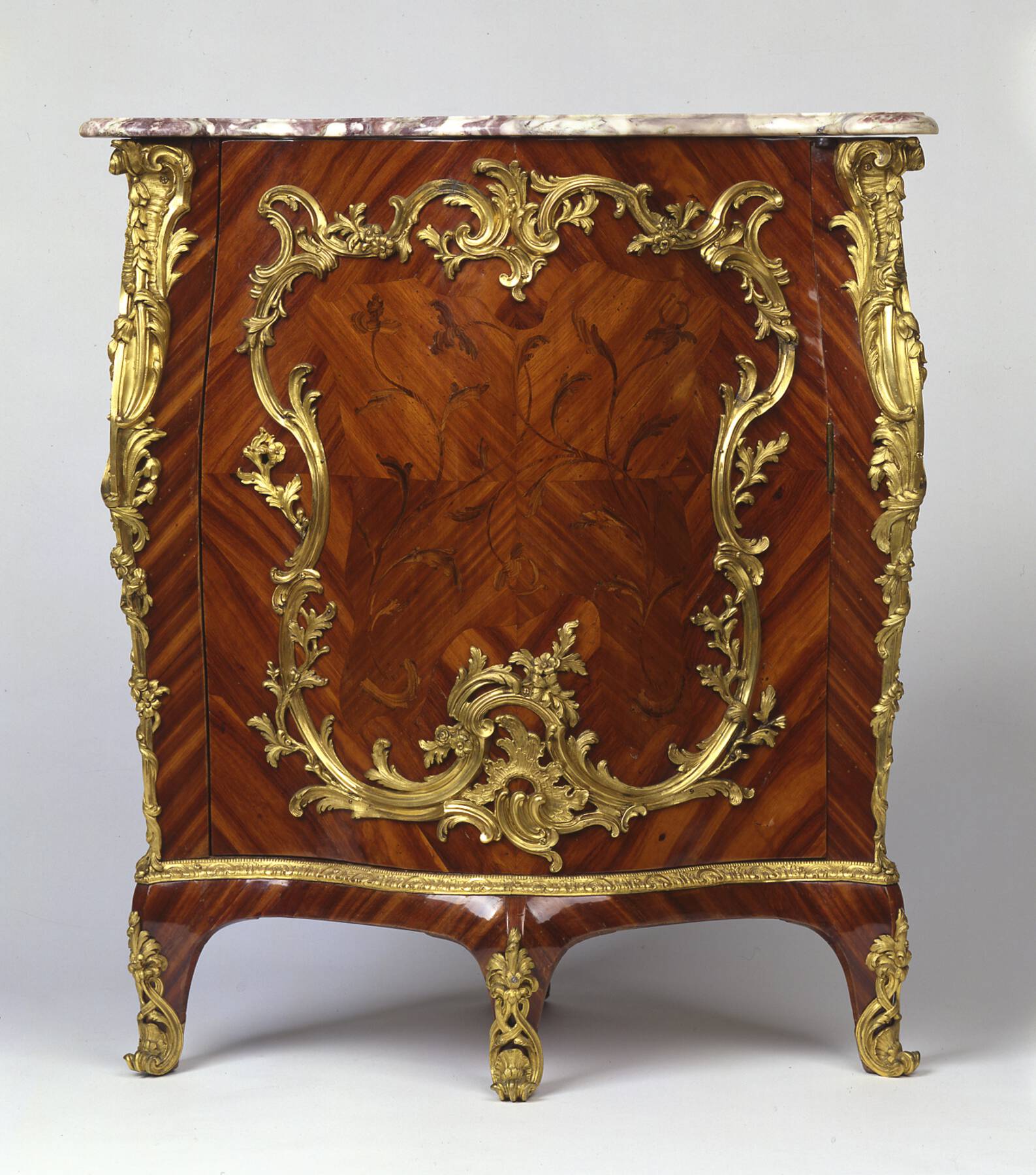 frontal view of an additional corner cabinet, decorated with floral veneer, rather than lacquer designs, and curvilinear gilt bronze mounts