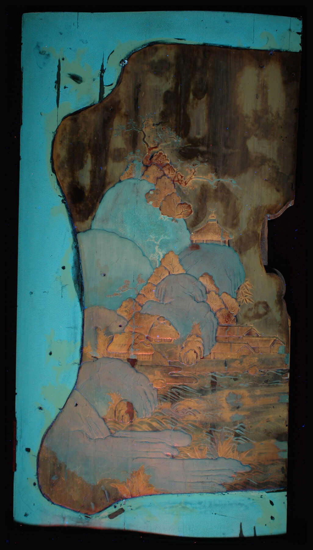left door of one of the cabinets under ultraviolet light, which reveals the various shades of turquoise, copper, and brown that are indicative of materials added to the cabinet during restoration processes