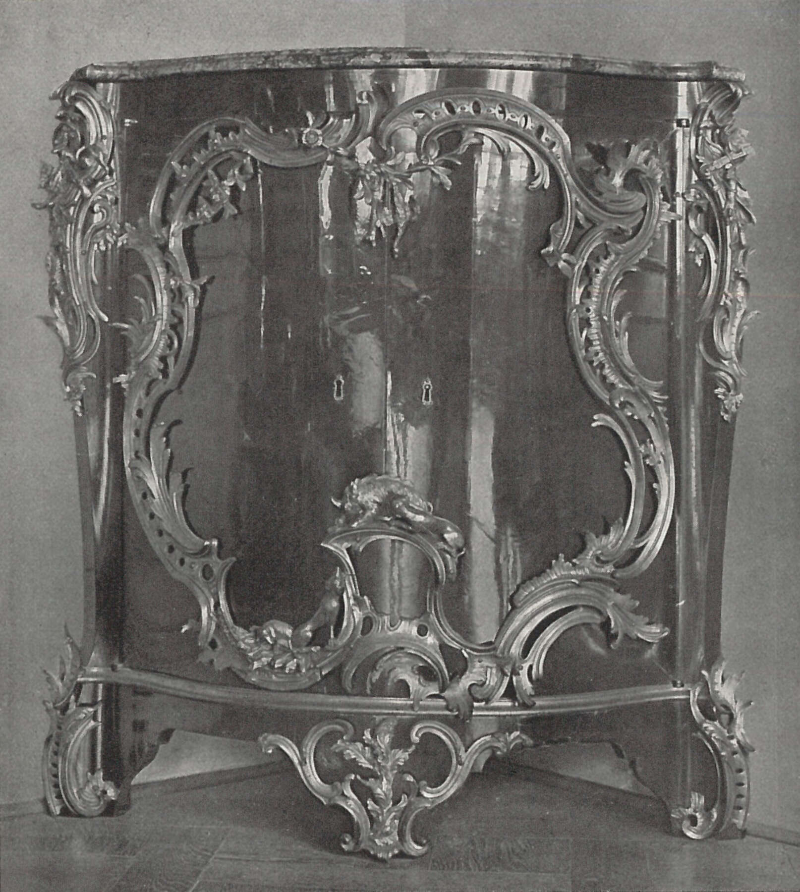 black and white image of a corner cupboard, more rounded in shape than Getty’s commode
