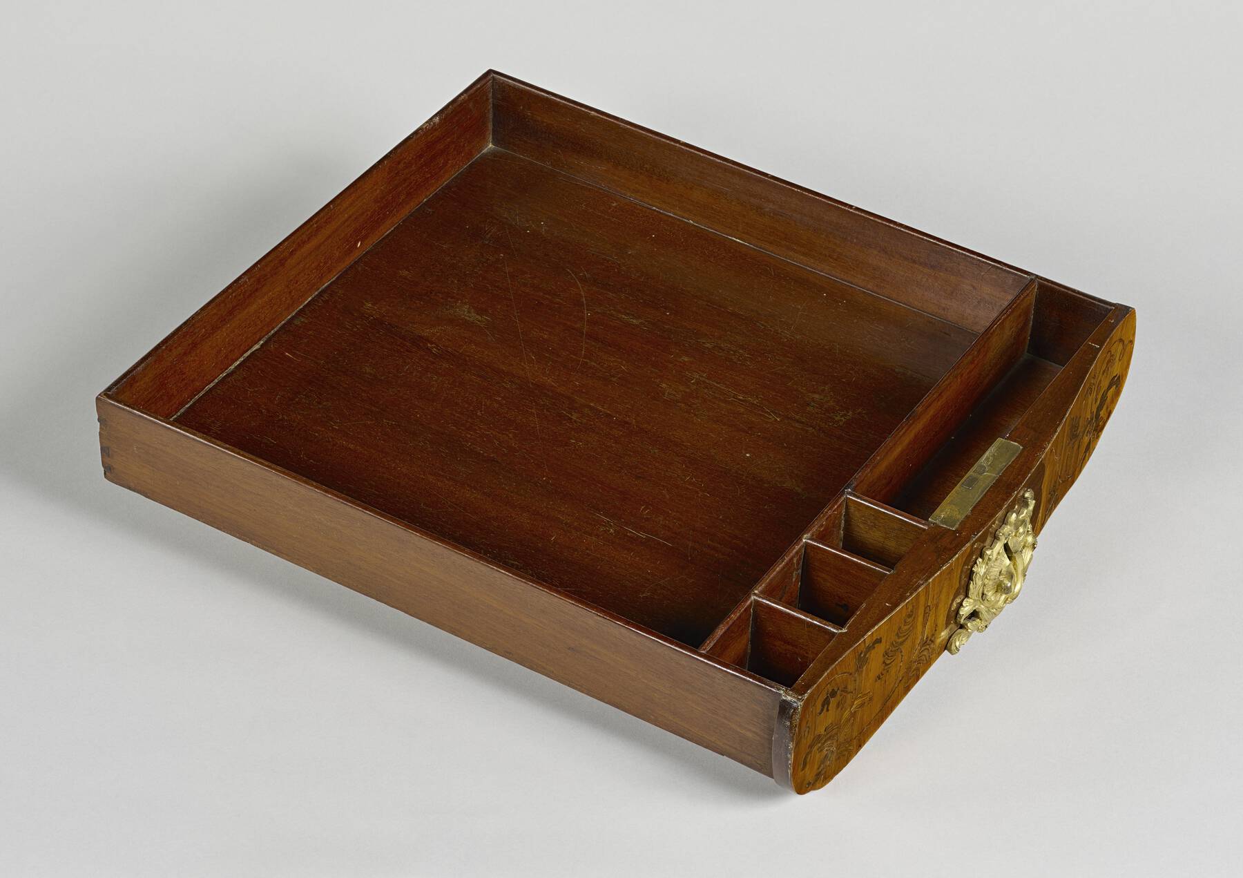 detail of one of the inner drawers, with one large square compartment in the back and four smaller compartments in the front: three small squares and one long rectangle