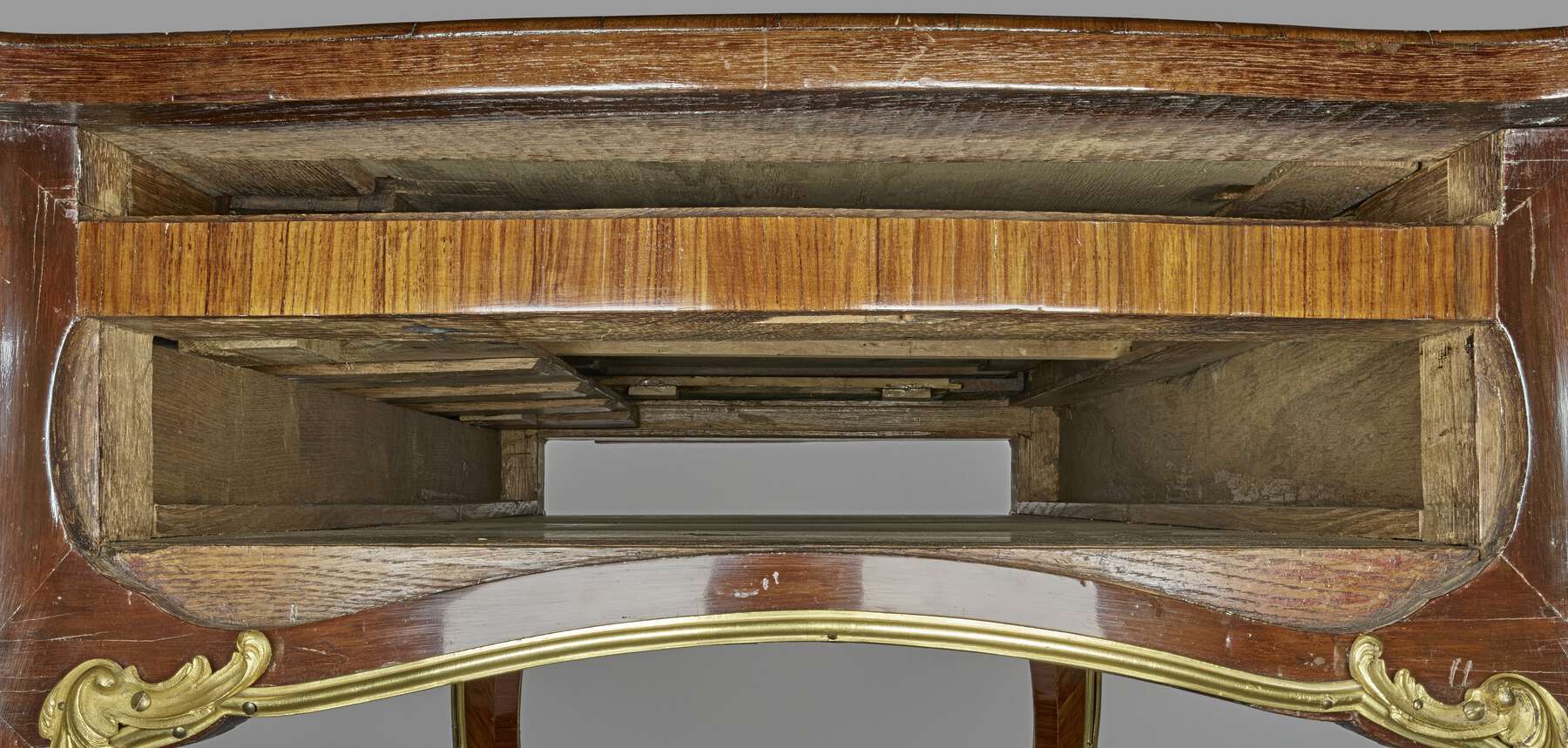 interior view of the table, showing a glossy finished wood on the outside and a rougher unfinished interior made up of multiple wooden strips